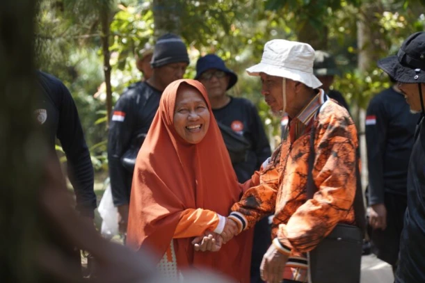 Potret Ustadz Wakhidin dan istri, Ibu Nuriah, tersenyum bahagia dalam balutan pakaian hangat bernuansa oranye saat mengikuti kegiatan Kembara PKS Jateng di lereng Gunung Merbabu.